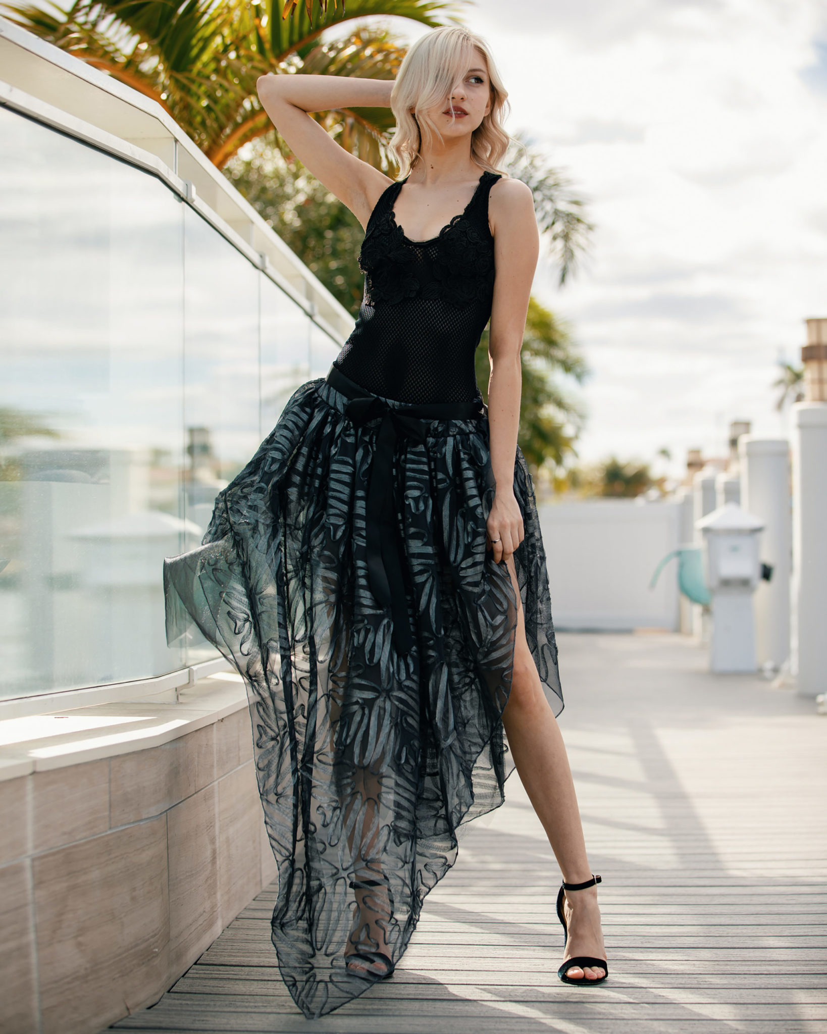 Sheer beauty: A double-layer handkerchief skirt, designed in a lush 3D pattern of silver tones and illusion threads, pairs seamlessly with a black body suit that’s enhanced by beaded Chantilly fabric flower details. (Model: Ashley Van Helden)